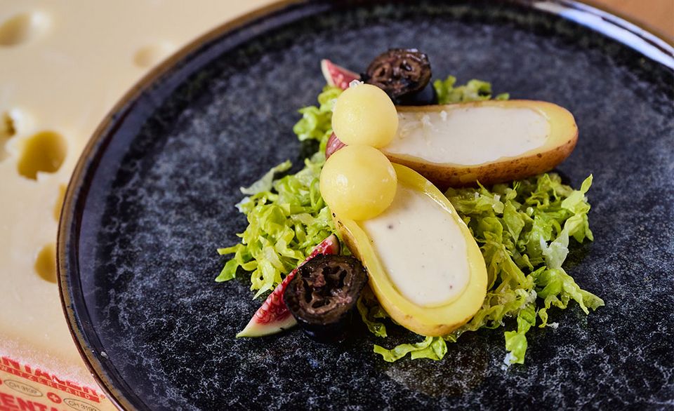 Bergkartoffeln mit Emmentaler AOP höhlengereift-Crème und schwarzen Nüssen sowie Lattichsalat.