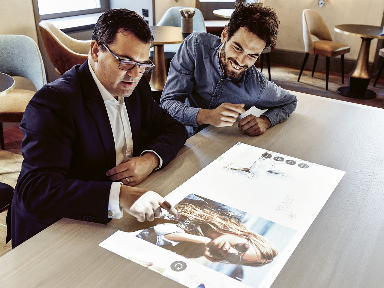 General Manager Michael Böhler (links) demonstriert in der digitalisierten Lobby, wie der Co-Working-Space für Präsentationen genutzt werden kann.