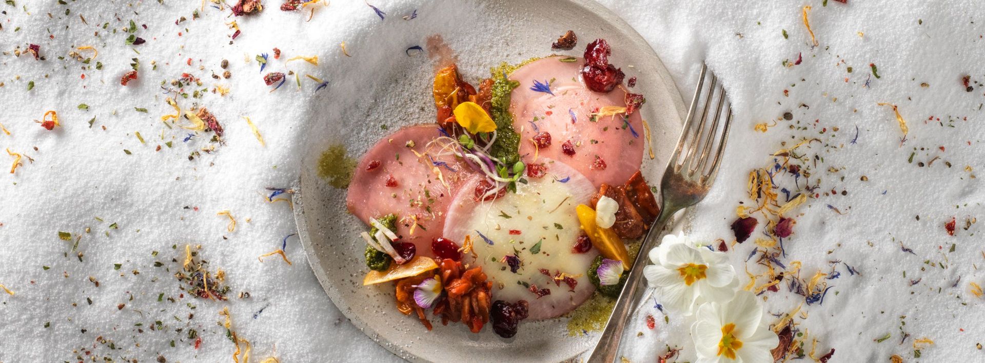 Kohlrabiravioli mit Portulak-Frischkäsefüllung auf Bärlauchpesto, sautierten Tomaten und Radieschen  Rezept von Milo Fuchs zur Gastrofacts-Titelseite N°41 - Frühling