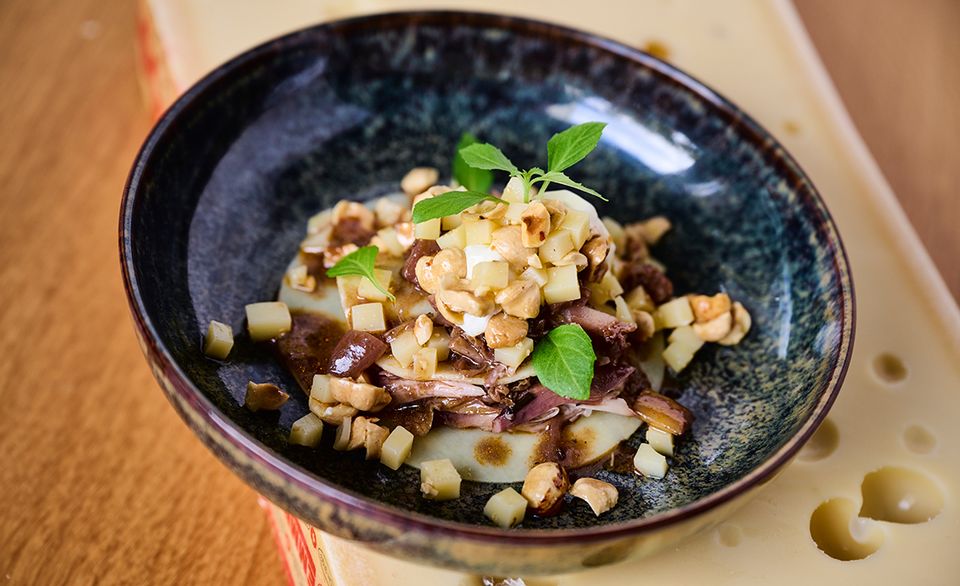 Offenes Coq-au-vin-Raviolo mit Emmentaler AOP und Surchoix-Haselnuss-Ragout.